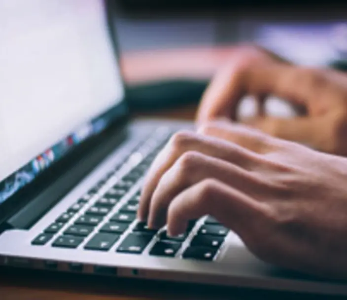 Laptop computer with fingers on keyboard