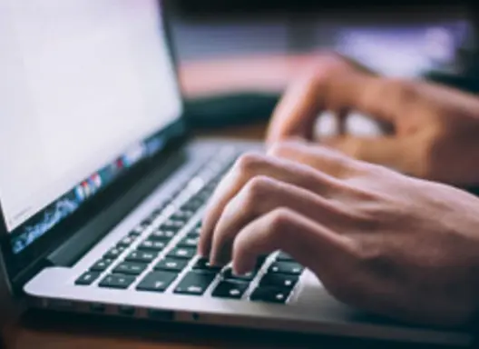 Laptop computer with fingers on keyboard