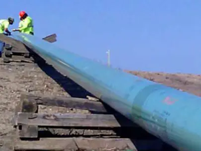 Construction workers installing a section of pipeline